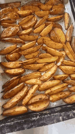 Запечённые дольки картофеля с румяной корочкой на противне